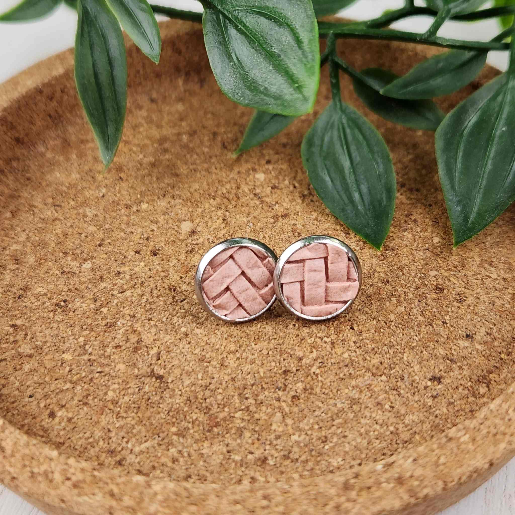 Hypoallergenic studs with salmon colored inlay. Inlay is a basket weave patterned faux leather. Studs are 10mm in diameter.