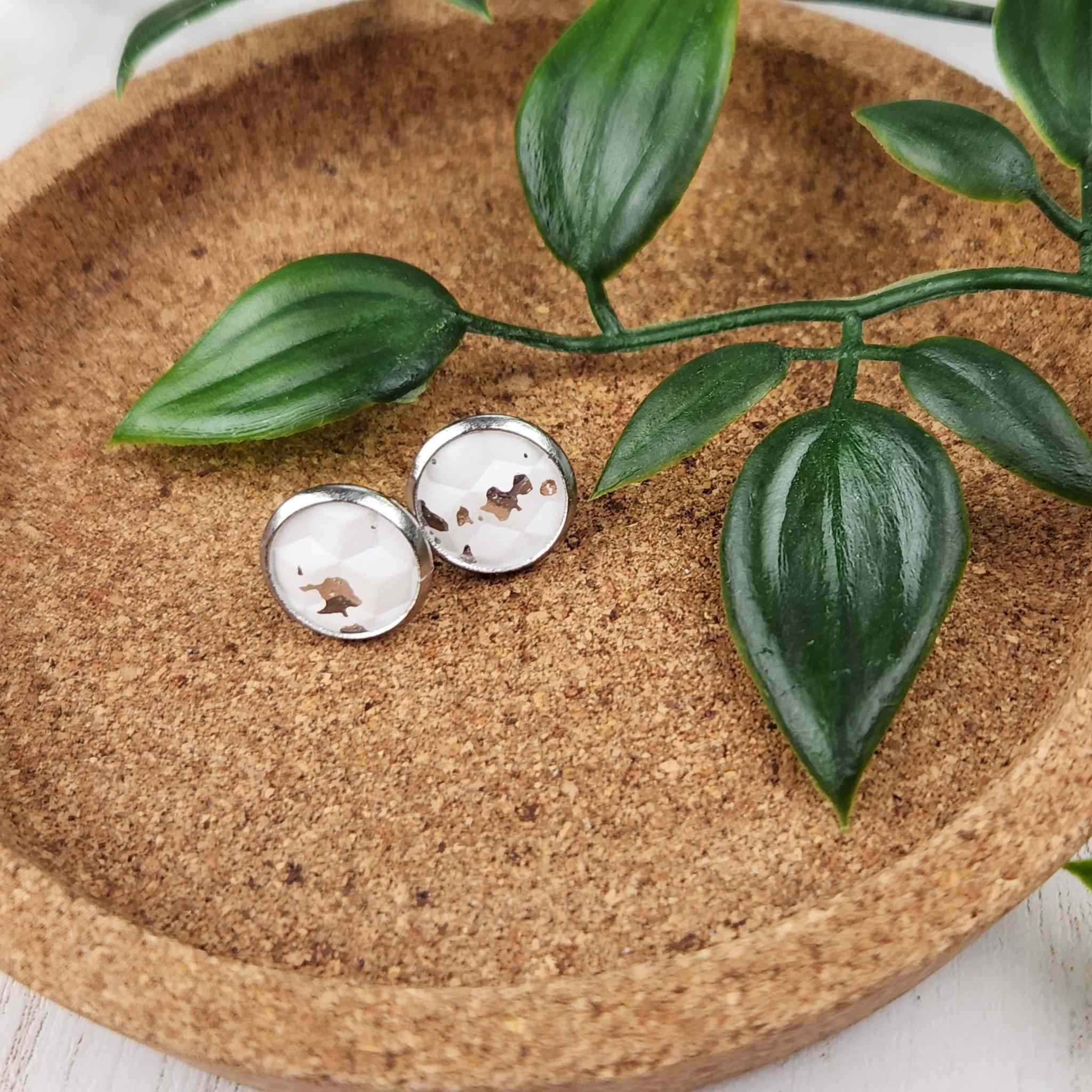 Hypoallergenic silver plated studs with faux leather inlay. Inlay is an elegant white pattern with silver speckles. Studs are 10mm in diameter.