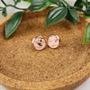 Hypoallergenic rose gold studs with faux leather inlay. Inlay is a speckled, salmon colored pattern. Studs are 10mm in diameter.