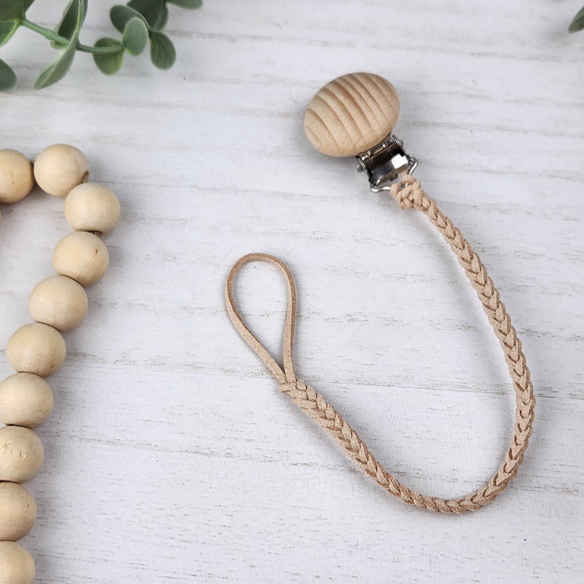 Beige soother clip with leather braided cord and a wooden clip