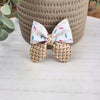 A leather sailor bow, has an alligator clip to fasten to hair, made with ice cream sprinkle pattern faux leather