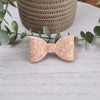 Coral glitter classic bow made with faux leather, has an alligator clip to fasten to hair.