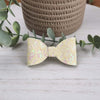 Yellow glitter classic bow made with faux leather, has an alligator clip to fasten to hair.