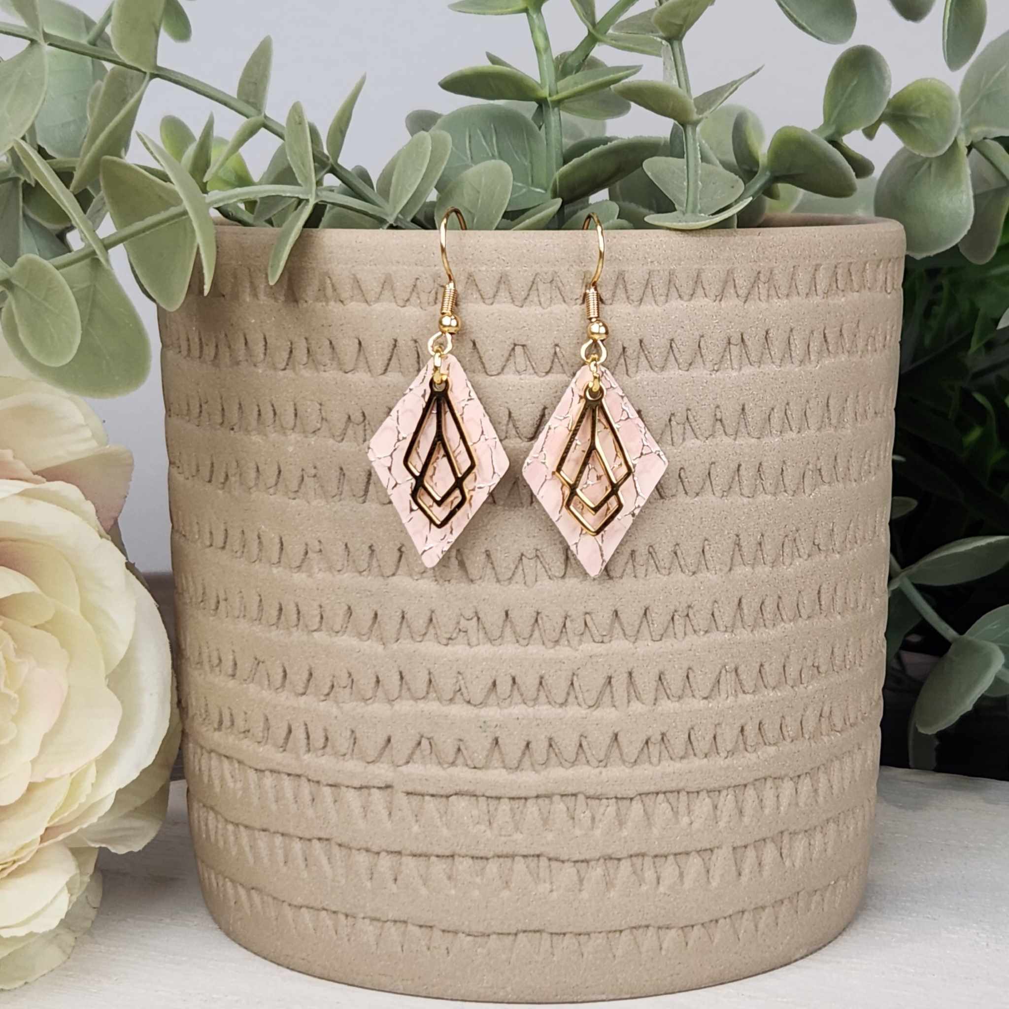 Soft pink and gold snakeskin faux leather with a gold filigree. Made with Hypoallergenic hooks.