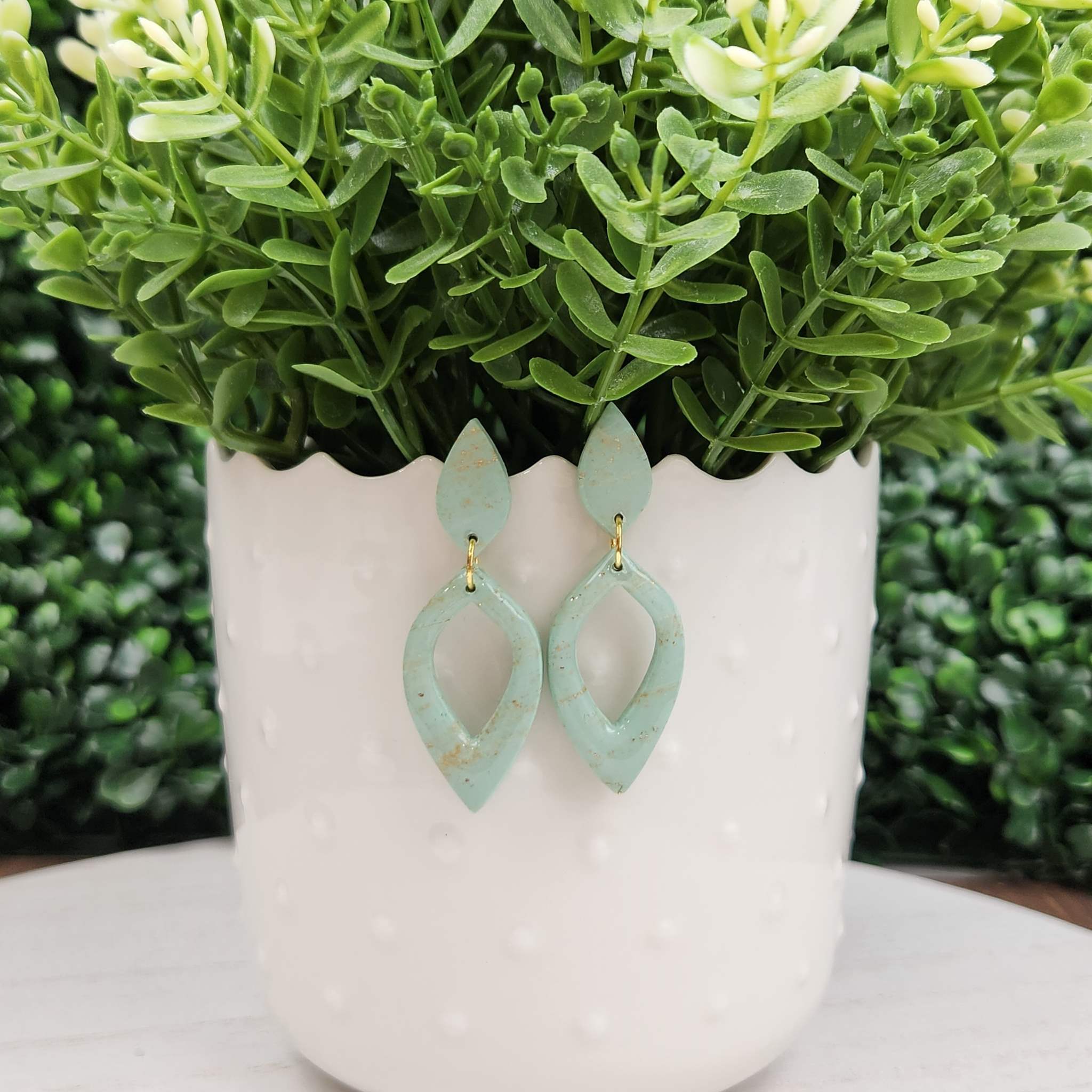 Mint marble clay earrings with gold flake detail and a hexagon charm.
Made with hypoallergenic posts.
65mm in length.