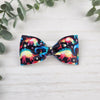 Dinosaur pattern bowtie. Has an adjustable strap with a clasp to easily attach around your neck.